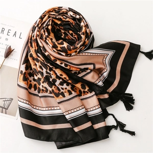 Detail view of silk shawl with leopard print, stripes, and black tassel edges
