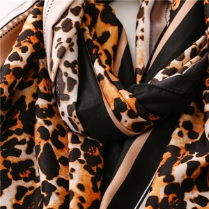 Close-up of leopard print silk scarf featuring fine stitching and smooth fabric texture