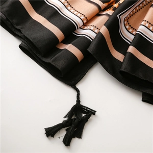Detailed close-up of leopard print silk scarf featuring premium tassels and woven texture