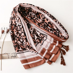 Close-up of leopard print silk shawl with elegant tassels and striped pattern detail