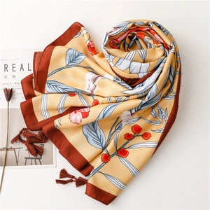 Detailed view of ginger floral silk scarf with elegant leaf patterns and brown tassels