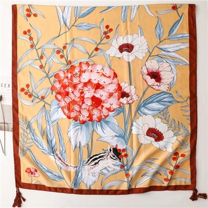 Detail of floral silk shawl with red tassels, squirrel print, and mustard yellow fabric