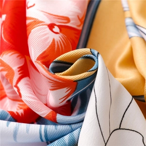Macro shot of ethnic floral silk scarf fabric showing fine twill texture and tassels