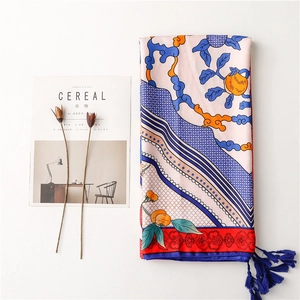 Detail of silk scarf showing ethnic totem patterns and handmade dark blue tassels