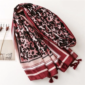 Close-up of wine red leopard print silk scarf featuring delicate fringe trim details