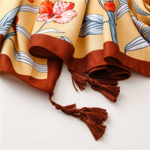 Detail of floral silk shawl featuring ginger base color with fringes and smooth texture
