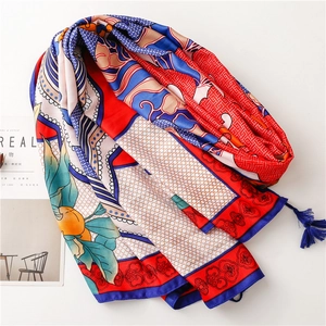 Detail view of ethnic red and blue silk shawl with intricate patterns and tassel accents