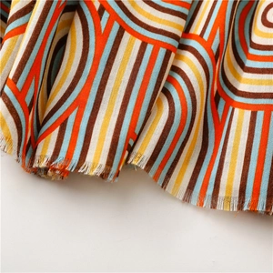 Detailed view of colorful geometric patterns and fine fringe on cotton linen scarf fabric