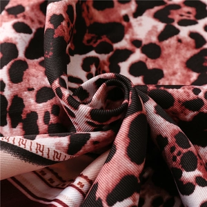 Detailed macro shot of leopard print silk scarf fabric with red and black twill texture