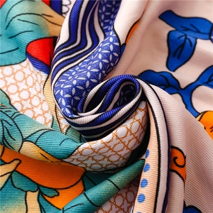 Close-up of vibrant floral silk scarf showing twill texture and detailed ethnic patterns