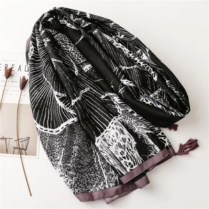 Detailed view of bohemian floral beach shawl with black abstract print and elegant tassels