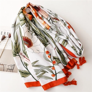 Close-up of floral print silk shawl with bright orange blossoms and fringe tassels