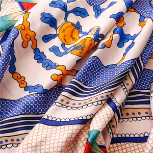 Close-up of silk scarf fabric showing intricate ethnic patterns and vibrant vine details