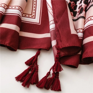 Close-up of leopard print silk shawl featuring ethnic geometric borders and elegant tassels