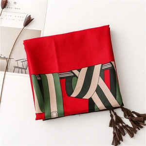 Vue détaillée d'un foulard en soie rouge avec rayures vertes et bords à franges denses