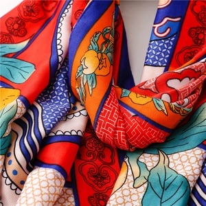 Detail of silk shawl featuring traditional cloud and floral totems with refined satin texture