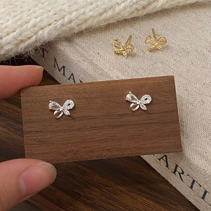 Ensemble de boucles d'oreilles papillon en argent et zircon sur support en bois