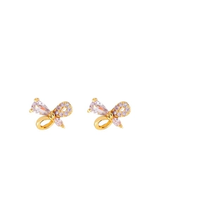Boucles d'oreilles papillon dorées avec zircons roses sur fond blanc élégant