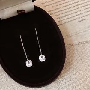 Detail of S925 sterling silver tassel earrings with halo cushion-cut crystal pendants