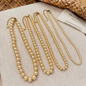 Lot de quatre colliers de perles dorées de différentes tailles avec fermoirs mousquetons