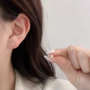 Minimalist silver stud earrings with sparkling round zircon displayed on a model ear