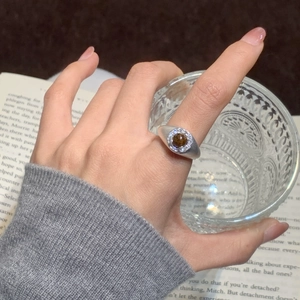 Detail of vintage gold-plated tiger eye ring with zircon halo on model's finger