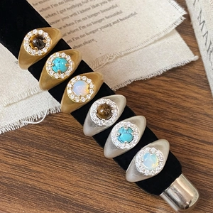 Vintage gold and silver rings set with turquoise and opal stones on black velvet display