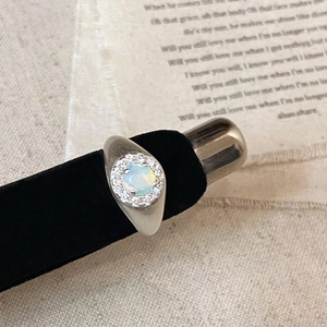 Macro shot of vintage halo opal ring with shimmering fire and cubic zirconia details