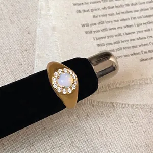 Macro view of vintage gold plated ring featuring white opal and zircon accents