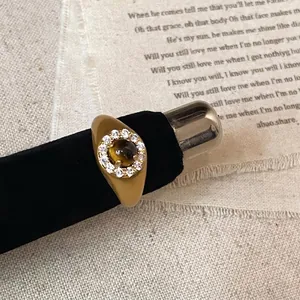 Macro detail of vintage gold-plated ring with tiger eye stone and zircon inlays