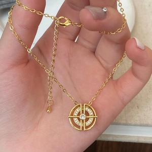 Détail du pendentif sphère astronomique dorée avec zircones cubiques sur une chaîne à maillons