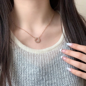 Rose gold geometric necklace with circular star pendant worn by model on white top