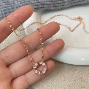 Rose gold geometric necklace featuring a star-shaped crystal circle pendant on cross chain