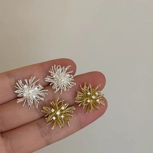 Close-up of dandelion stud earrings with cubic zirconia in silver and gold finishes