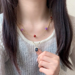 Double-layered gold necklace with colored beads and black rectangular zircon pendant