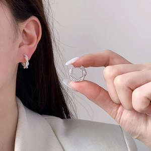 Élégantes boucles d'oreilles créoles torsadées en argent portées par un mannequin femme