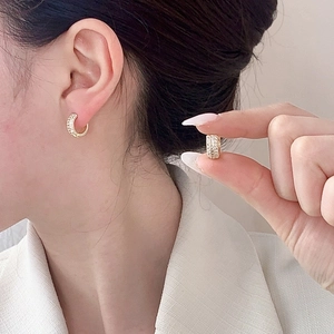 Luxurious gold-plated wide hoop earrings with micro-pave crystals on model and in hand