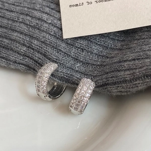 Detail view of silver micro-pave hoop earrings with three rows of shimmering zircons