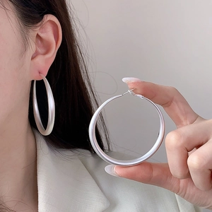 Boucles d'oreilles créoles oversize en argent mat au design élégant et minimaliste