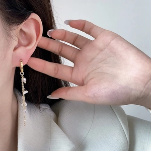Vintage flower tassel earrings with gold chains and crystals on a model's ear