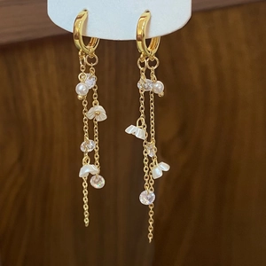 Vintage flower tassel earrings with white blossoms and pearls on dark wood