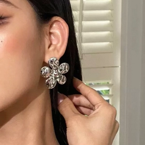 Boucles d'oreilles fleur vintage avec texture martelée sur modèle et lumière douce