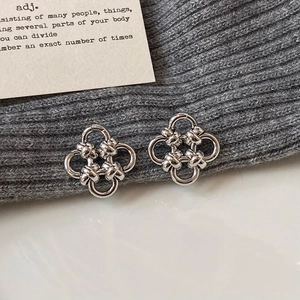 Elegant silver four-leaf clover stud earrings with a polished twisted metal design
