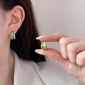 Minimalist gold and green enamel C-shaped hoop earrings worn on model for a retro luxury look