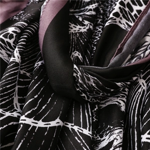 Detail of floral print silk scarf featuring black, white and purple leaf patterns