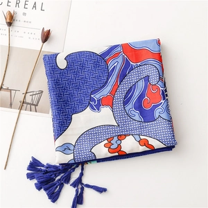 Detail of blue and red silk scarf featuring ethnic wave patterns and delicate tassels