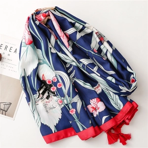 Close-up of floral pattern silk scarf with elegant red fringe tassels and blue print
