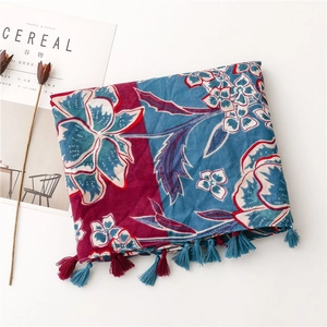 Close-up of bohemian floral scarf with intricate navy and pink prints and tassel details