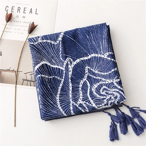 Macro detail of dark blue silk scarf with white wave patterns and tassel trim edges