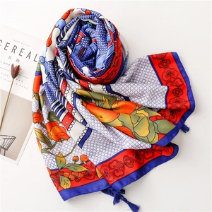 Close-up of floral print silk scarf with colorful totem patterns and blue tassels